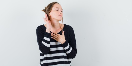 young-woman-standing-listening-pose-holding-one-hand-chest-while-closing-eyes-striped-knitwear-black-pants-looking-happy-3-_main